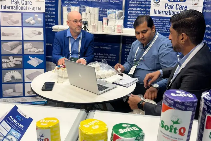 A buyer and the Pak Care team discussing samples, with SoftQ absorbent cotton wool rolls in front